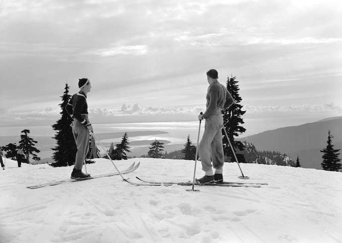 1940-Two skiers looking at a view of Point Grey and Stanley Park from the top of MtSeymourBC