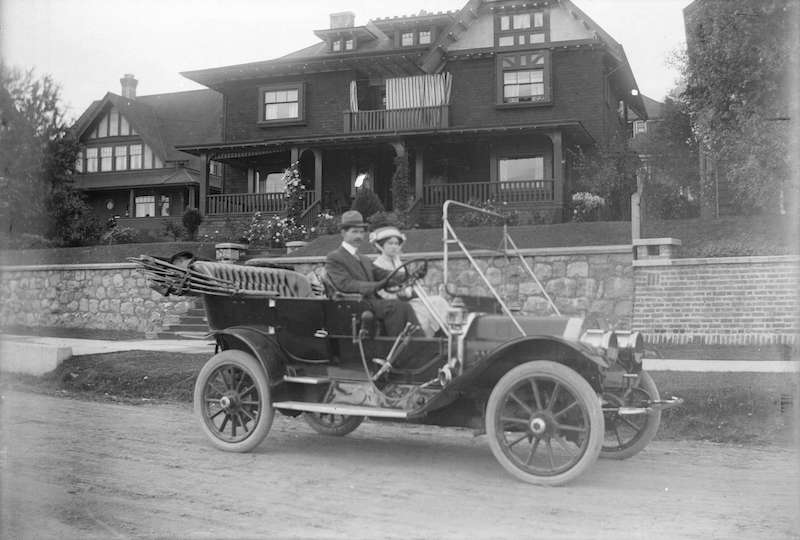 1900?-Man and woman sitting in car in front of house