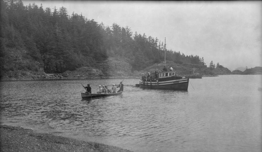 1910?-Group of people being transported from boat to shore in canoe