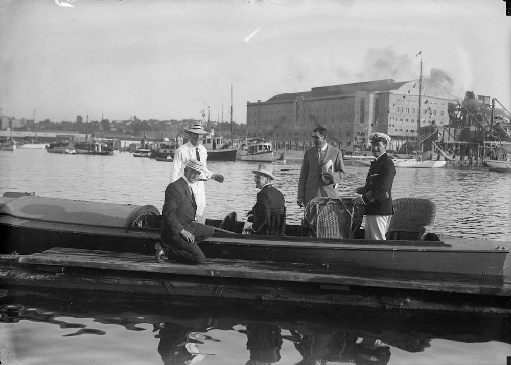 1913-An officer and civillians on a small boat at the dock