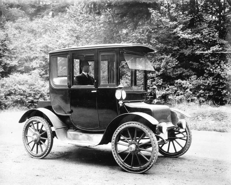 1913-Man seated in electrically operated coupe style car