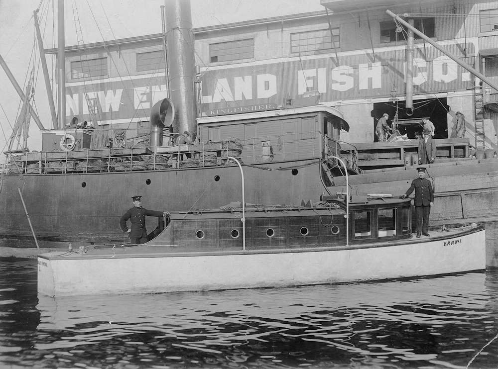 1920-police patrol boat docked in front of the New England Fish Co. building