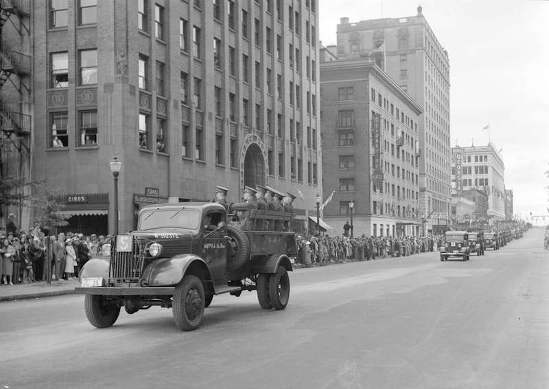 1938-A parade of military vehicles travelling west along Georgia Street