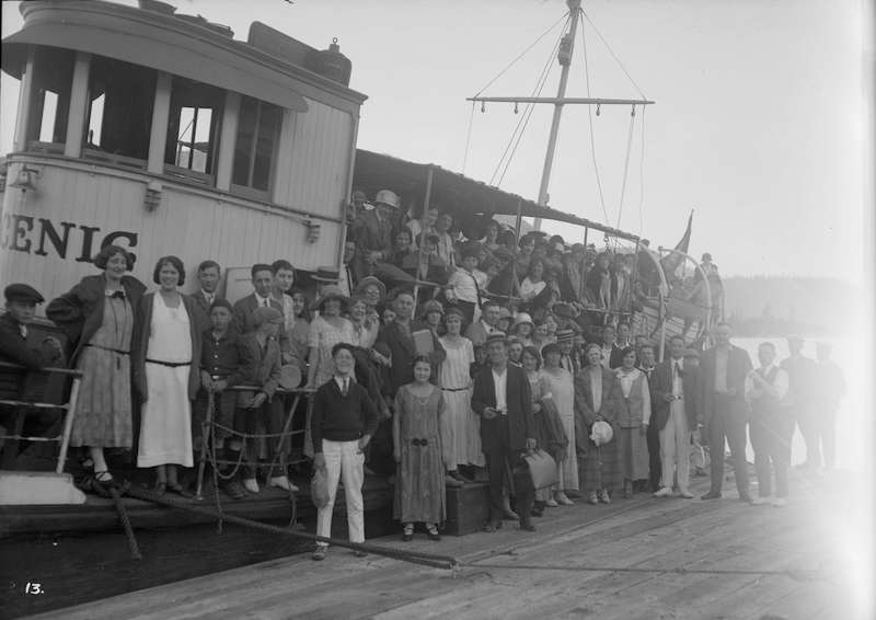 1924 - A group posing on the dock next to a boat