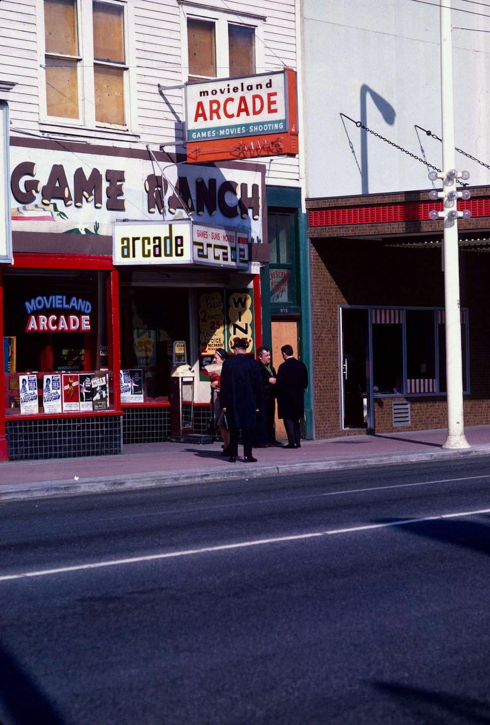 1969 - View of a sign, storefront Game Ranch, Theatre Row, [Movieland Arcade at 904 Granville Street