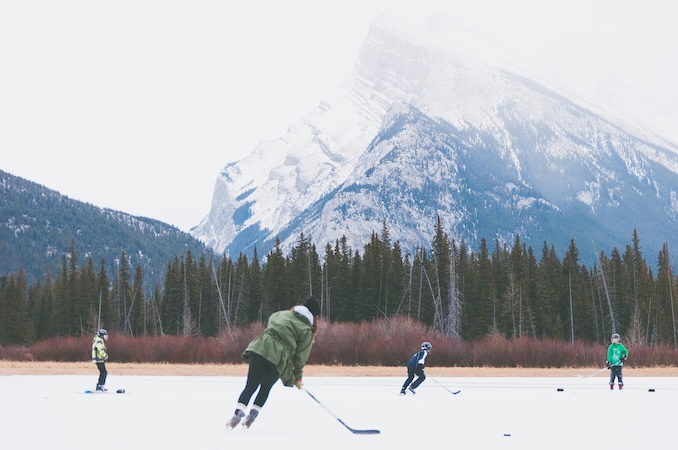 Hockeys players on a lake in the mountains.