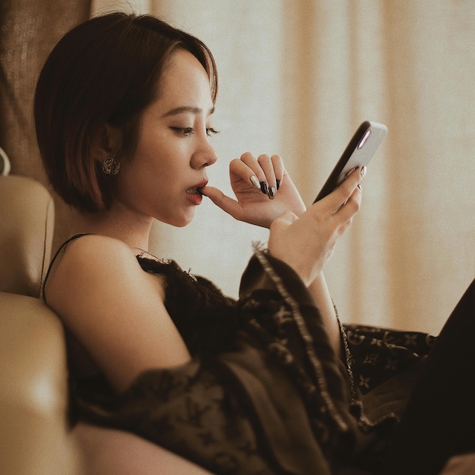 Woman using her cell phone while sitting down.