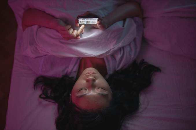 Woman on her phone in bed.