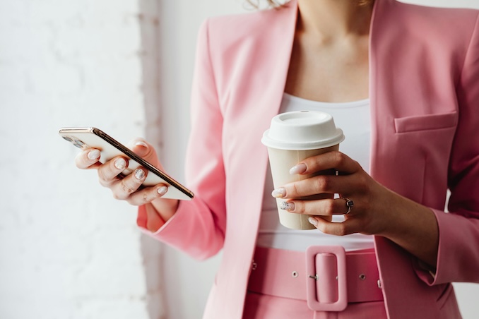 Woman dressed in pink using her cell phone.